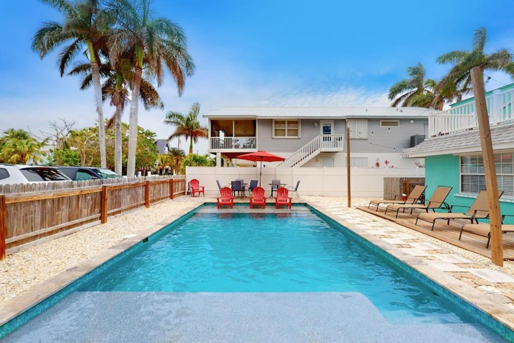 a swimming pool with chairs and a house at Bungalow B in Bradenton Beach
