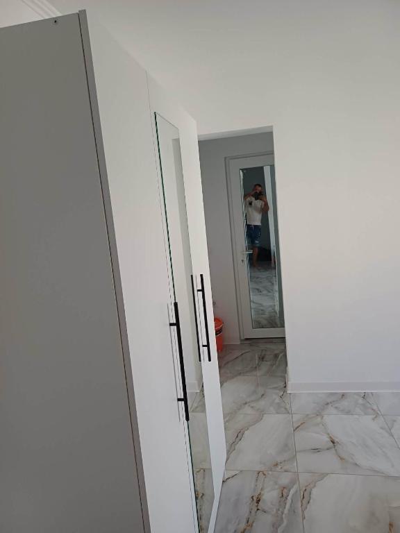 a person taking a picture of a mirror in a bathroom at Ibo in Brăila