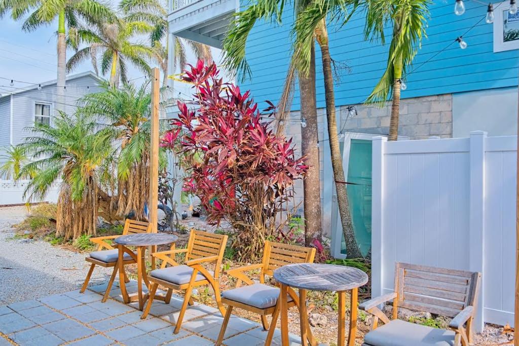a group of tables and chairs and palm trees at Bungalow W in Bradenton Beach
