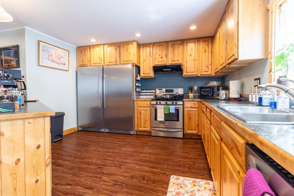 a kitchen with wooden cabinets and stainless steel appliances at Alaska Adventures Lodge in Seward