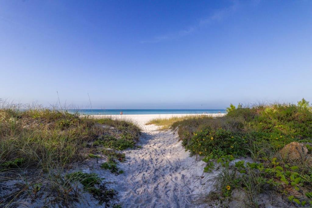 a sandy beach with the ocean in the background at Pineapple House in Holmes Beach