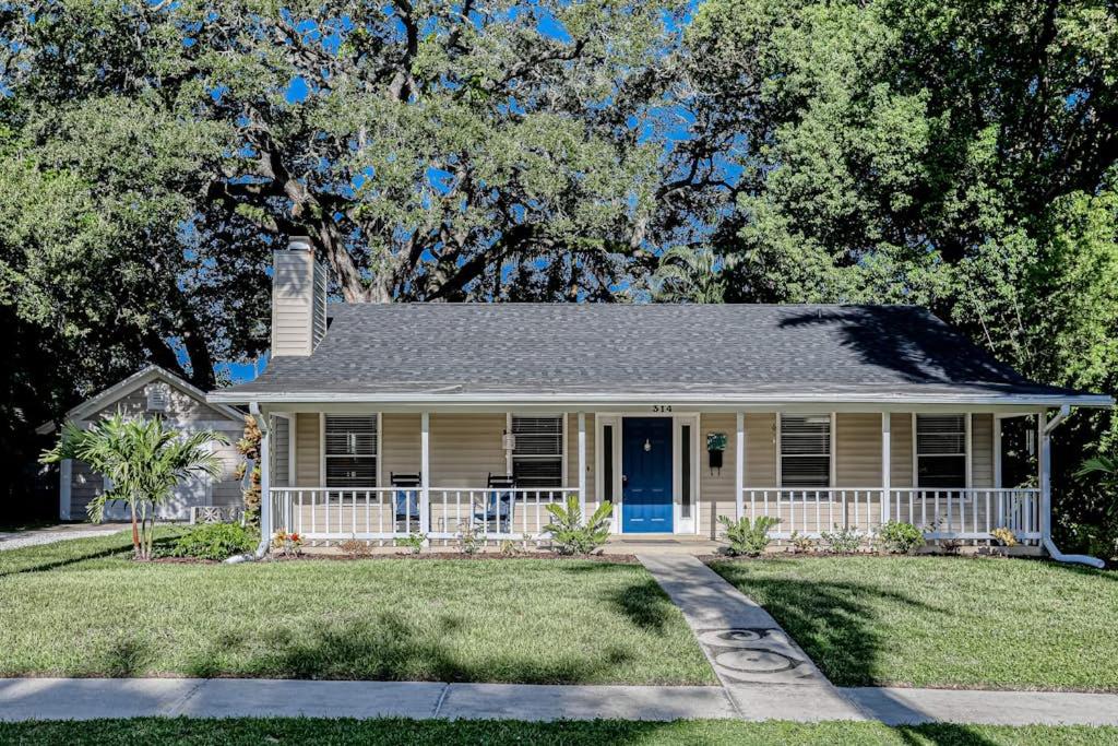 a small yellow house with a blue door at Manatee River House in Bradenton