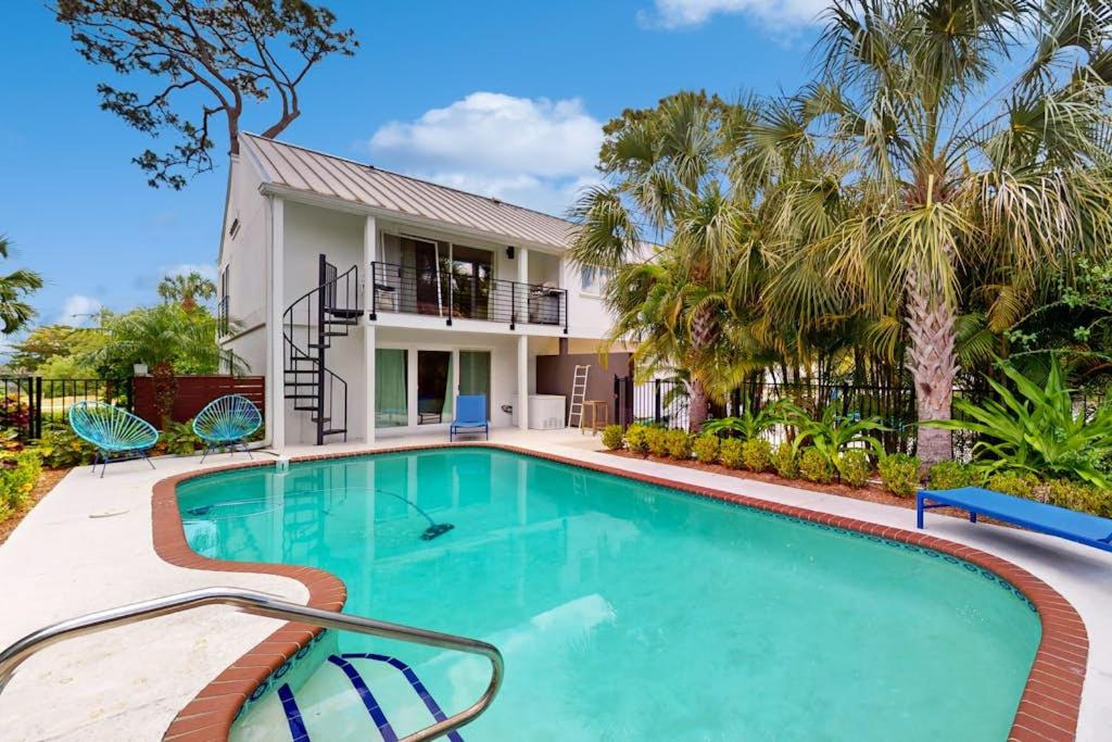 a swimming pool in front of a house with palm trees at 10 Pines - Sarasota Bay in Sarasota