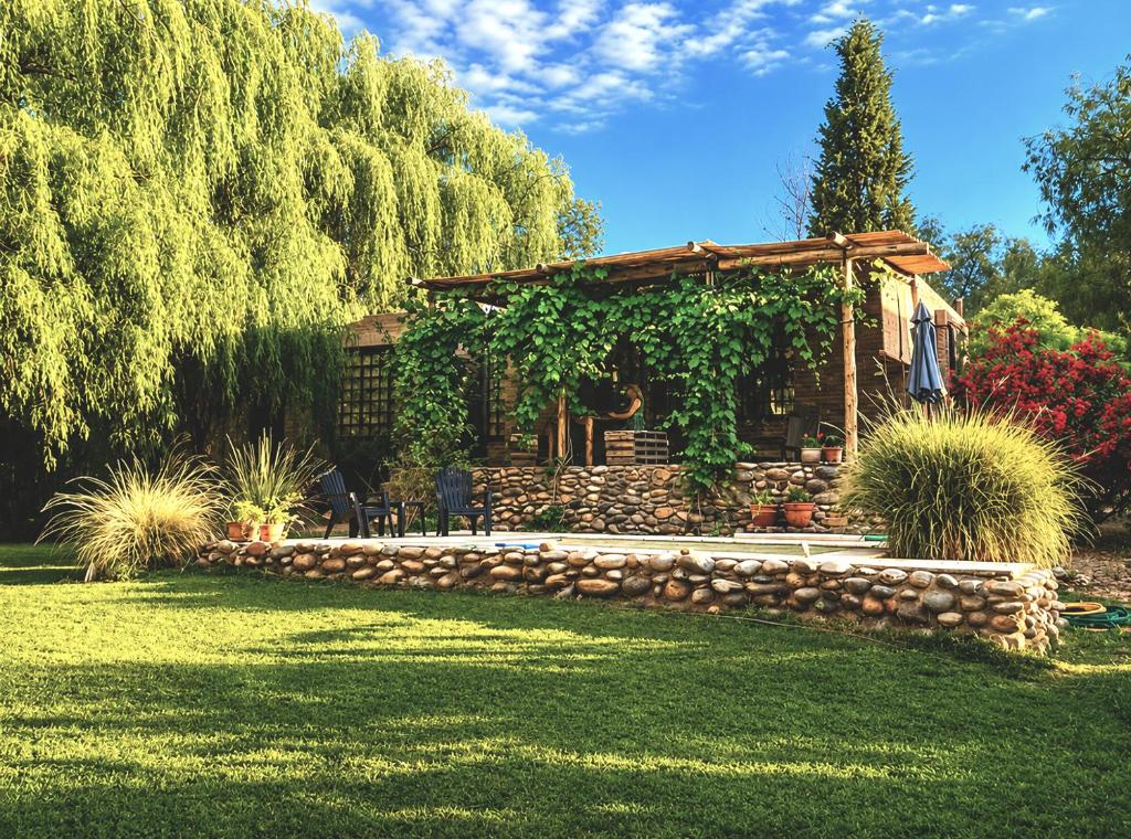 a house with a stone fence and a stone wall at Las Pircas, casa de campo in Ciudad Lujan de Cuyo