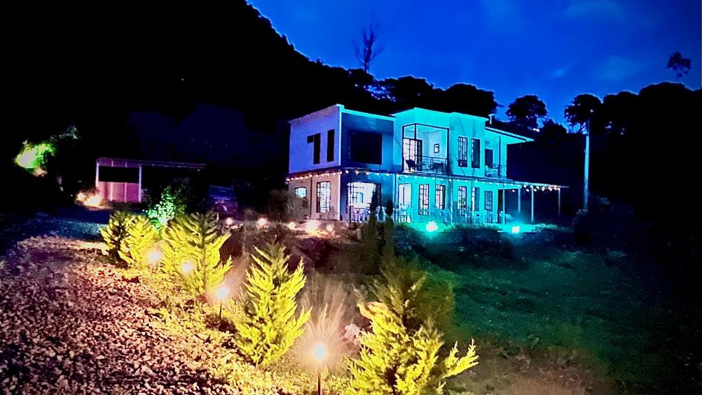 a blue house with christmas lights in front of it at Hospedaje choachi Housetraillyones in Choachí