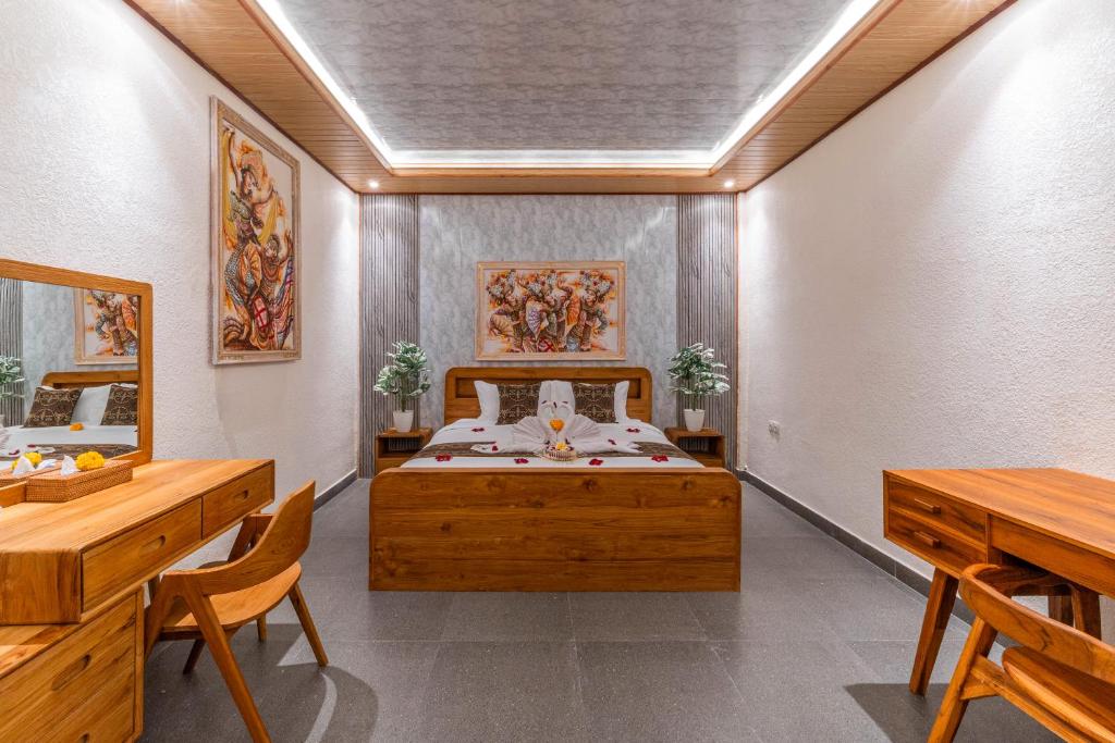 a bedroom with a bed and two tables and chairs at Junna House Ubud in Payangan