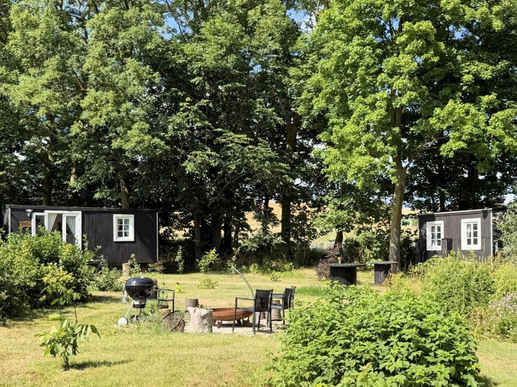 a couple of tiny houses in a yard with a grill at Nøddehaven in Eg