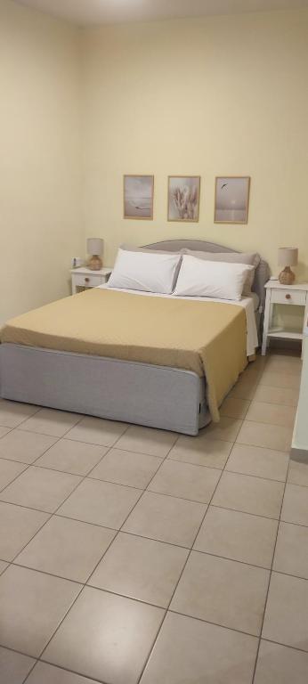 a bedroom with a bed with two tables and two pictures on the wall at Nicol's apartment in Ermoupoli