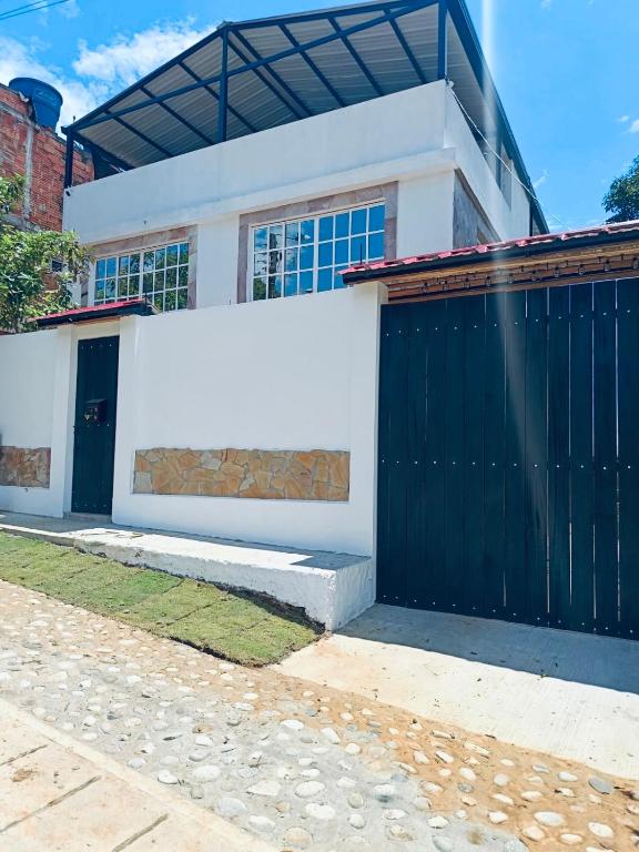 a house with a black and white garage at Habitaciones Stonehaven Ruitoque in Piedecuesta