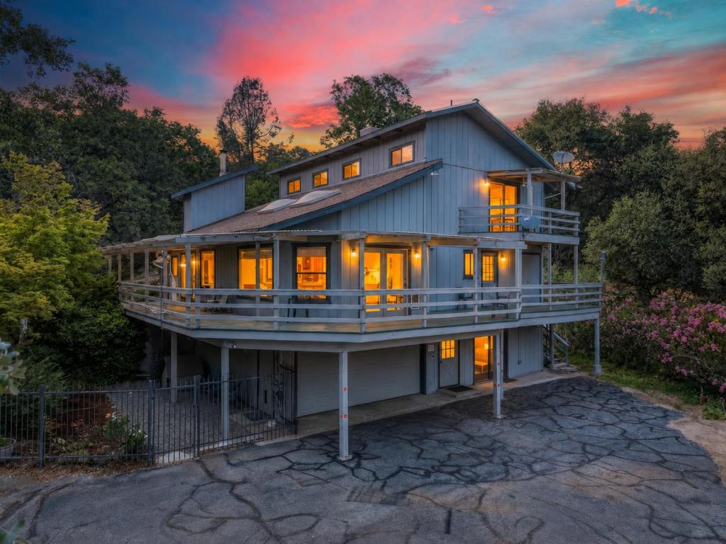 a house with a sunset in the background at Hodges Hill Hideout w/ pool, spa, BBQ - Dog Friendly in Oakhurst