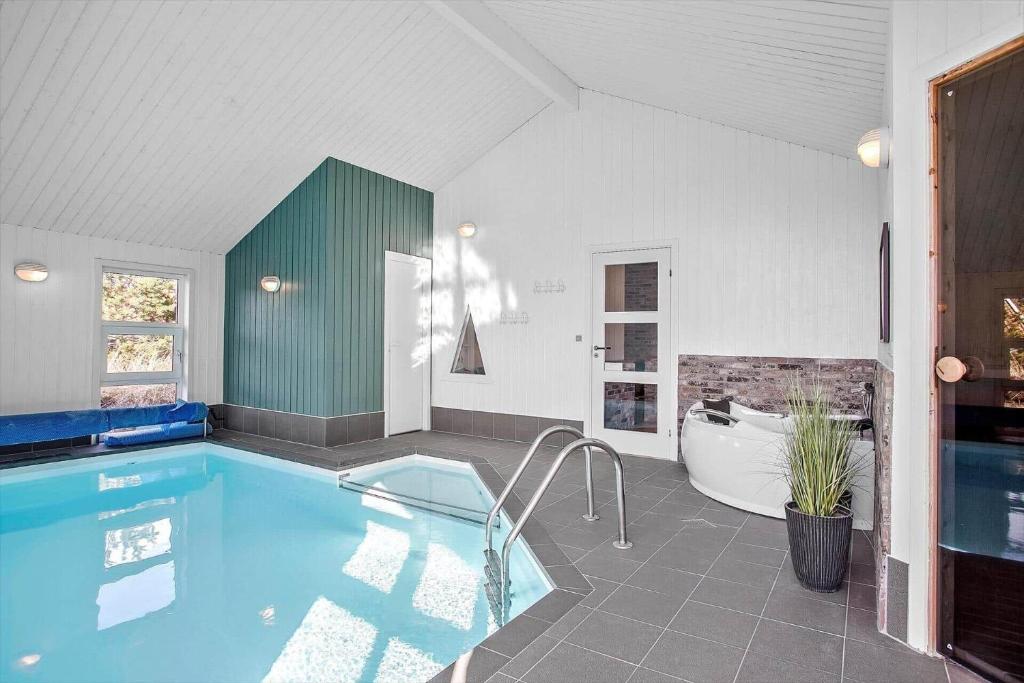 a large bathroom with a pool and a tub and a bath tub at 1005-Thisted-Spanggardsvej-39 in Torsted
