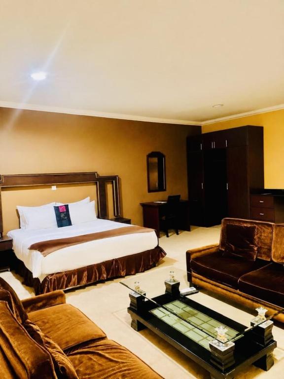 a hotel room with a bed and a couch at Gmasters Boutique Hotel in Kigali
