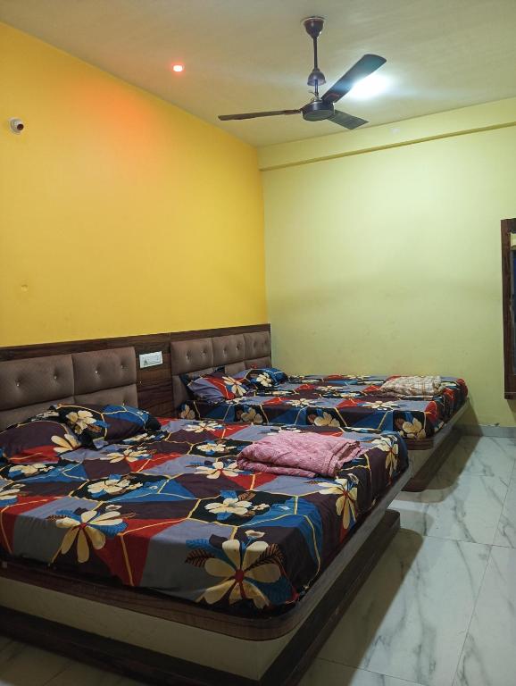 two beds in a room with yellow walls at Hotel sawariya in Godarpura