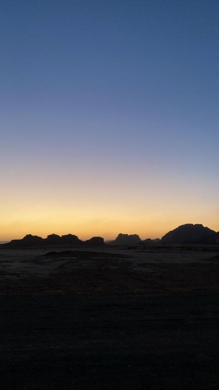 a sunset in the desert with mountains in the background at Maea wade ram in Disah