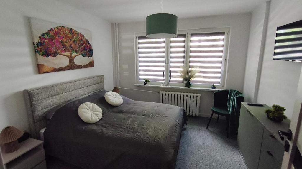 a bedroom with a bed with two pillows on it at Przy Głównej in Zamość