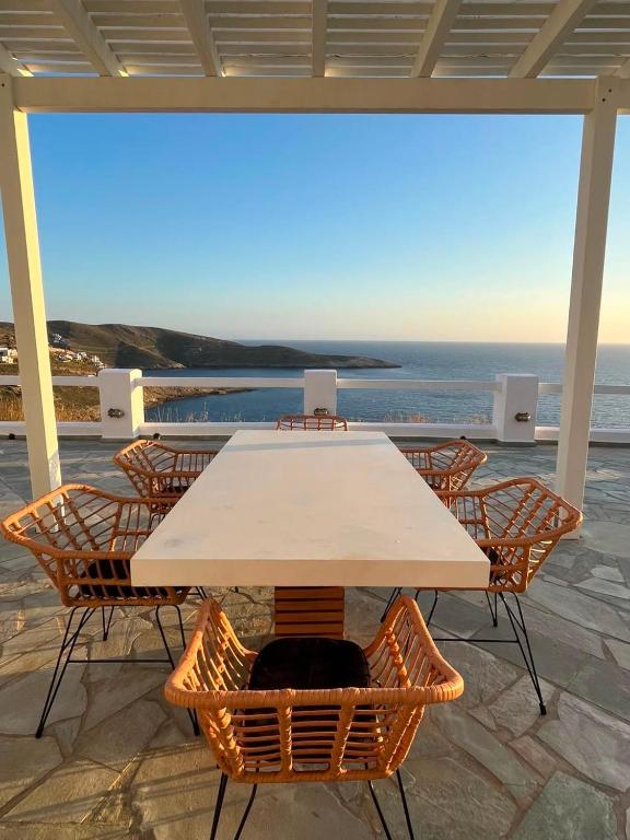 a table and chairs with a view of the ocean at Villa de Estrella in Agios Dimitrios