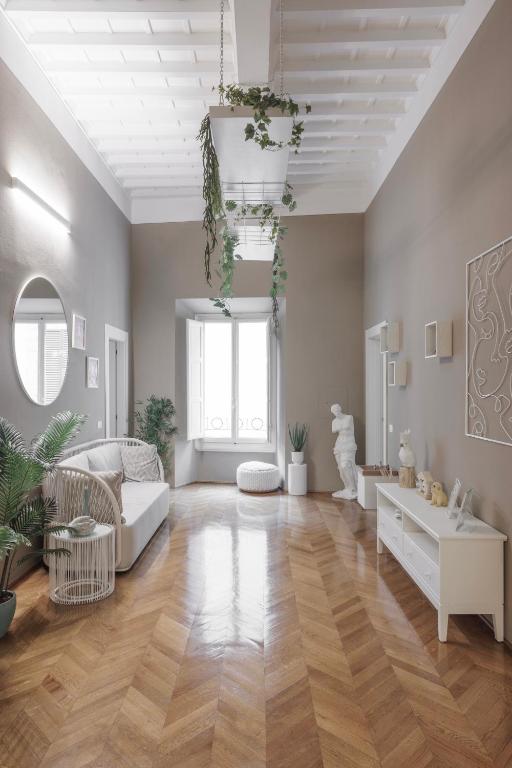 a living room with a white couch and wooden floors at Rooms Buonanotte Barbarossa in Prato