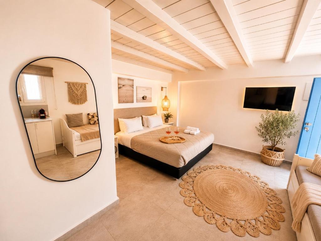 a bedroom with a bed and a mirror and a couch at ELEVEN KEYS APARTMENTS in Vrisi/ Mykonos