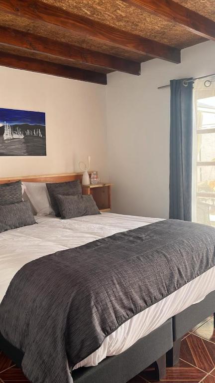 a bedroom with a large bed and a window at Hostal Malú in San Pedro de Atacama