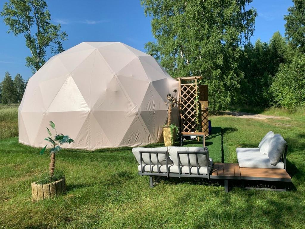 a white tent with a couch in a field at Couple Baltic Coast Retreat in Apšuciems