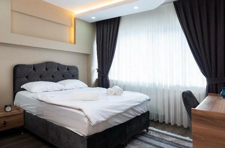 a bedroom with a large bed and a window at Saltanat Apartment in Istanbul