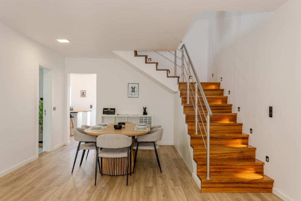 a dining room with a table and a staircase at The Frenchie's House in Rabo de Peixe