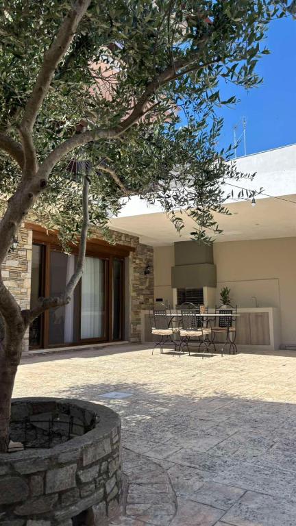 a patio with a tree and benches in front of a building at aganta apartments in Olympiada