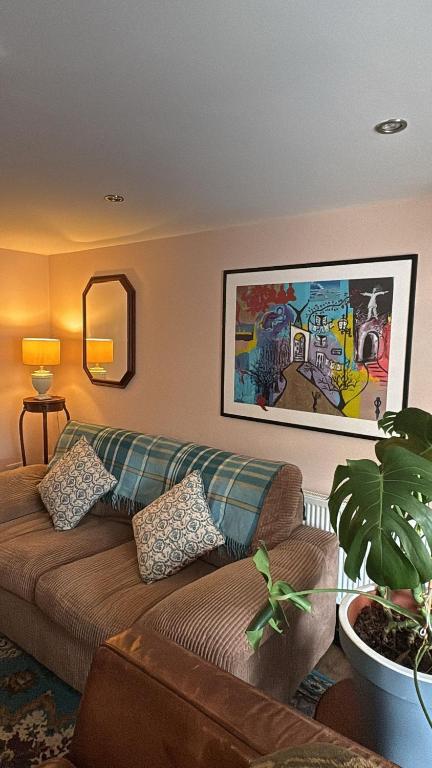 a living room with a couch and a painting on the wall at Croagh Patrick Studio in Murrisk