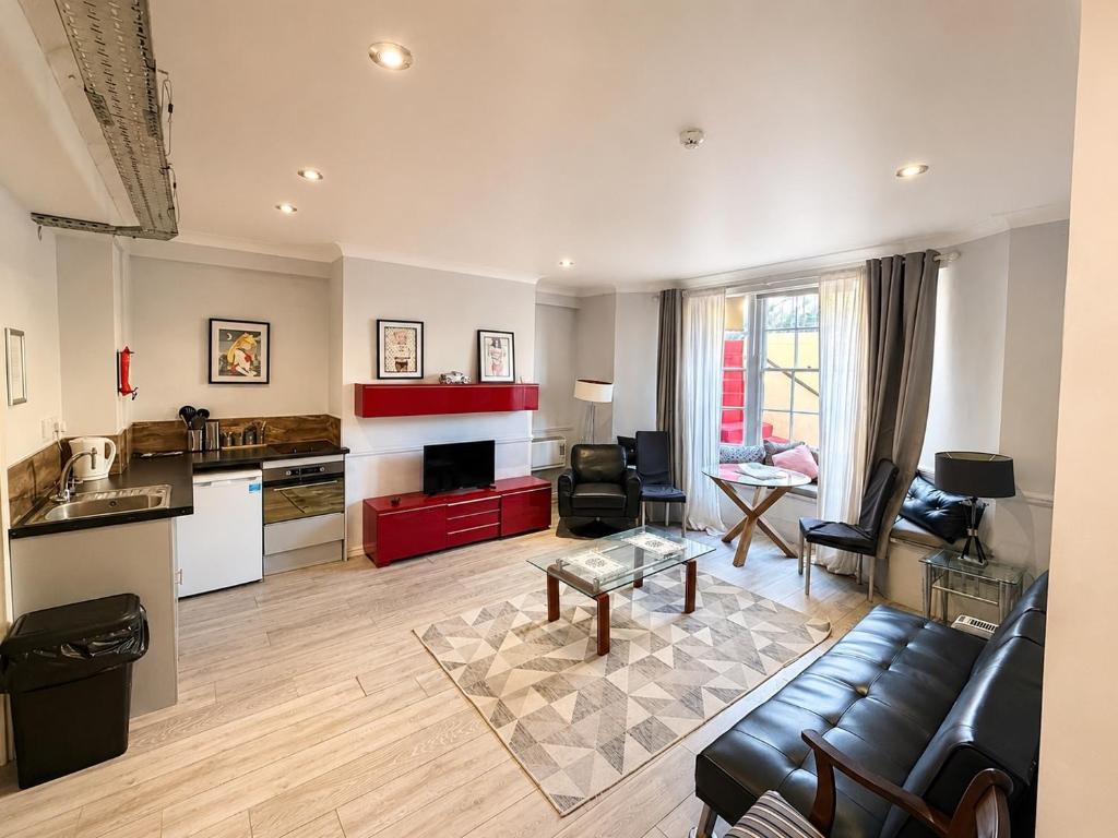 a large living room with a couch and a kitchen at 12A Regency Square in Brighton & Hove