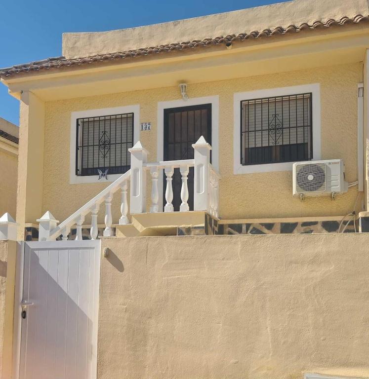 a house with a white fence and a balcony at Super Cute Camposol 2 bed with Community Pool in Mazarrón