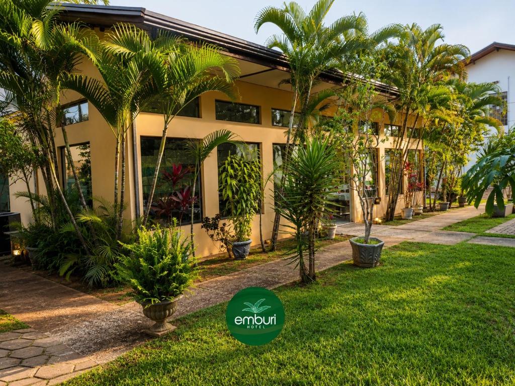 a house with palm trees in front of it at Emburi Hotel in Piratininga