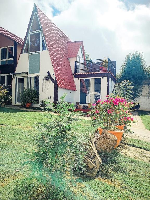 a house with a statue of a man in front of it at Cabaña, fogata, terraza in Santiago Sacatepéquez