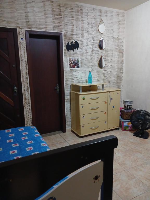 a bedroom with a bed and a dresser and a door at Suíte em casa particular in Lagoa Santa
