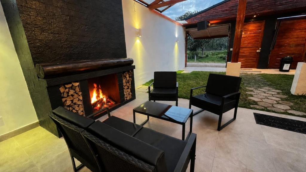 a living room with chairs and a fireplace at OXALAND HAUs in Oxapampa
