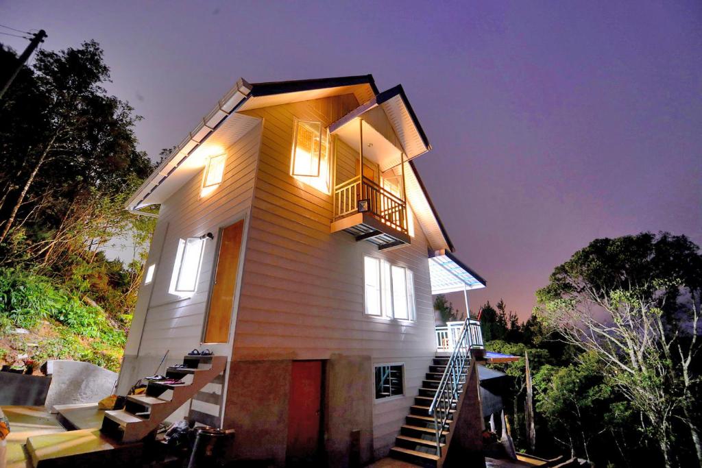 Kampong KundassanにあるT Paradiseの小さな家で、バルコニーが側面にあります。