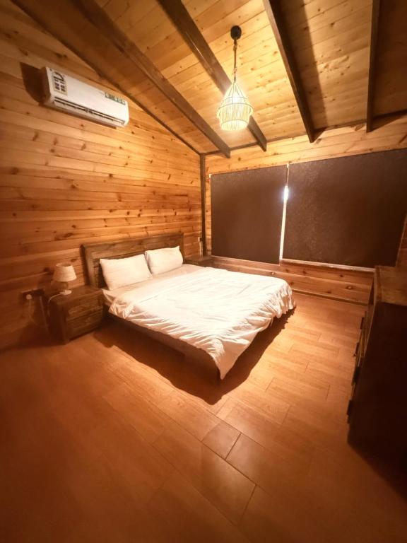 a bedroom with a bed in a wooden room at اكواخ بيلا 2 in Taif