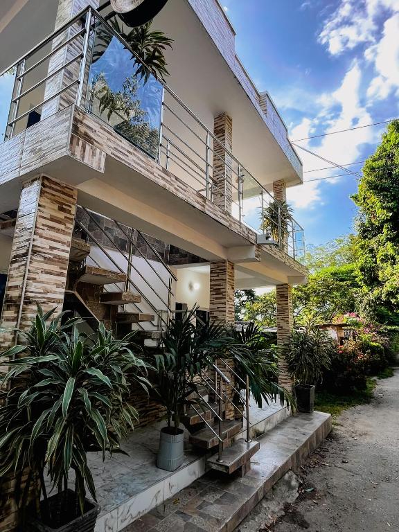 a house with stairs and plants in front of it at Hostal La Bendición Buritaca in Santa Marta