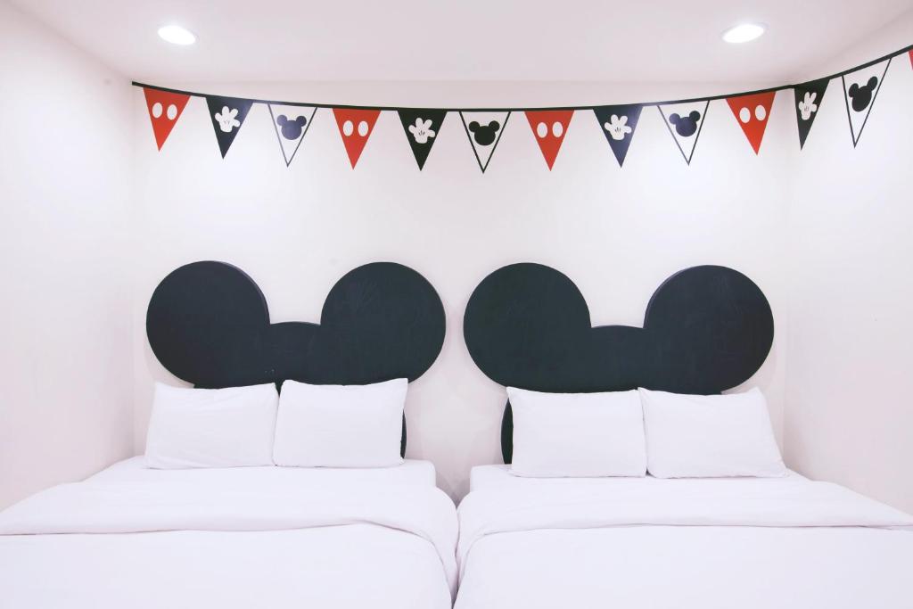 two beds in a room with flags and bunting at Lè mù in Taichung