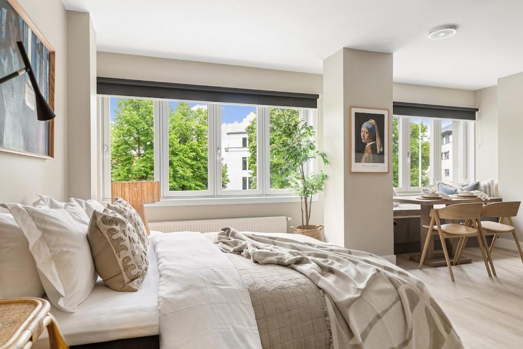 a bedroom with a bed and a dining room at Voy Stays Molde sentrum in Molde