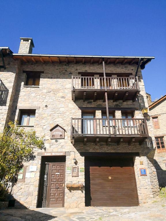 a large stone building with a balcony and two doors at Cases Artigues in Os de Civís