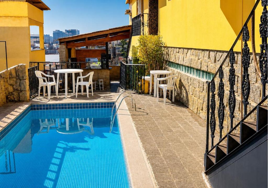 a swimming pool with tables and chairs next to a building at Apartamentos Porto Maravilha in Rio de Janeiro