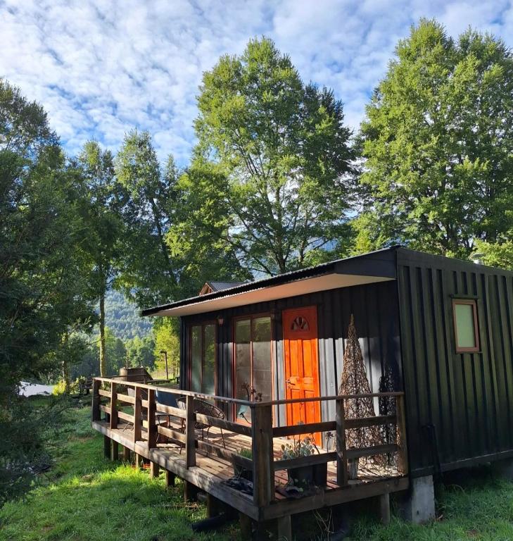 a black tiny house with a wooden deck at Rustika Tiny House in Pucón