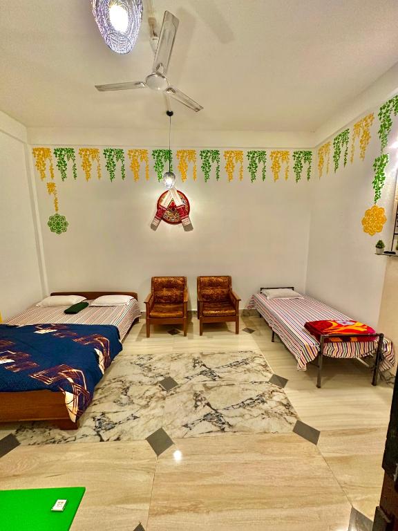a bedroom with two beds and a rug at NDM Homestay 2BHK in Sibsāgar