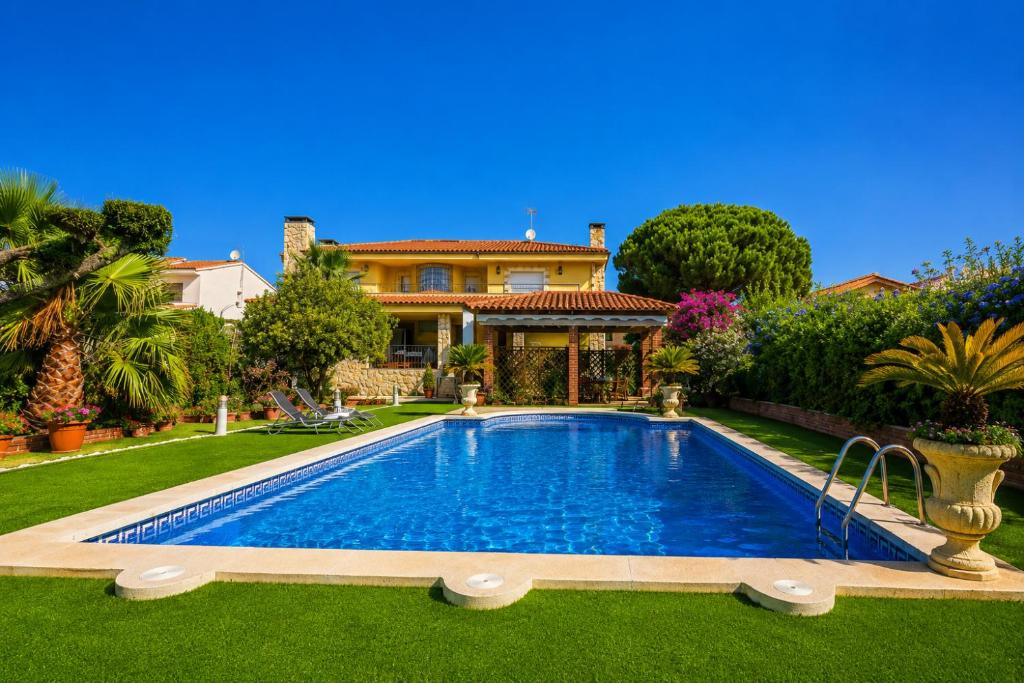a house with a swimming pool in front of a yard at Magnifica Planet Costa Dorada in Cambrils
