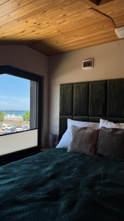 a bedroom with a large bed with a large window at Monic Apart Zefir in Mechelinki