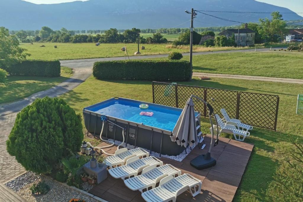 a swimming pool with lounge chairs and an umbrella at Family-friendly apartments with swimming pool Cepic, Central Istria - Sredisnja Istra - 11636 in Zatka Čepić