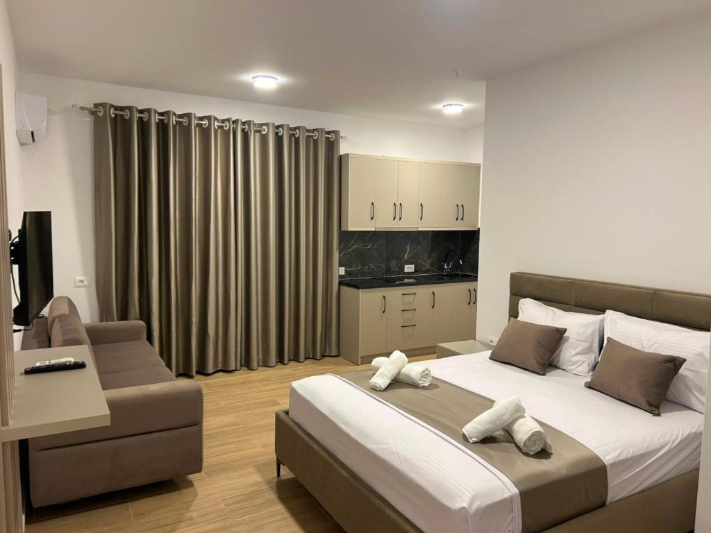 a bedroom with a large bed and a couch at Villa Dedi ,Borsh in Vane