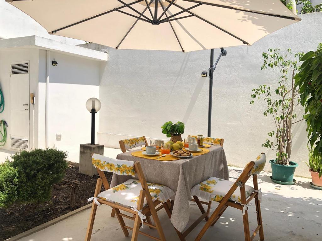 a table and chairs with an umbrella on a patio at Nuraghe house 36 in Cagliari