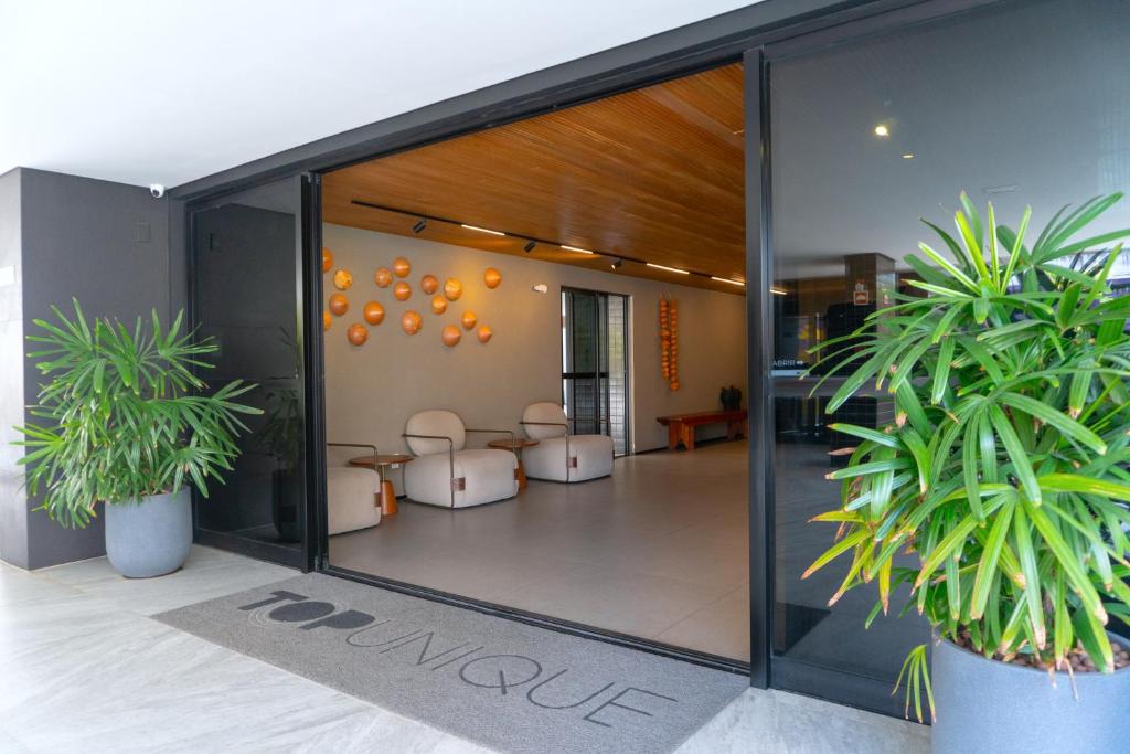 a lobby with two potted plants in a building at Top Unique Maceió in Maceió