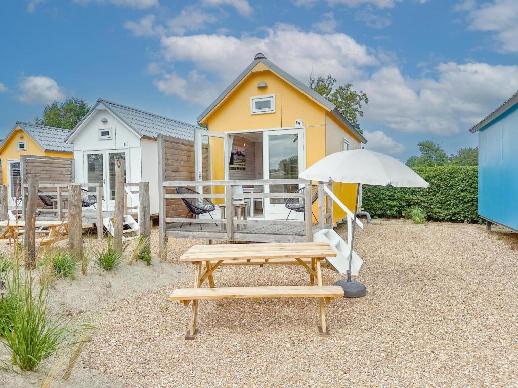 a house with a picnic table and an umbrella at Bumble bee in Ellemeet